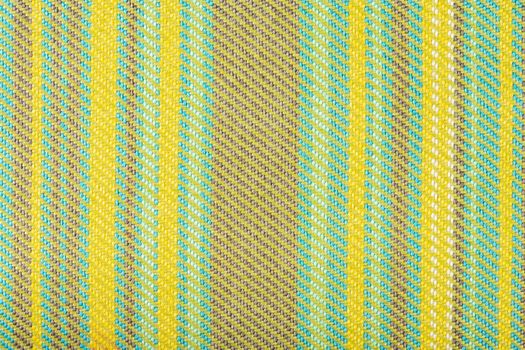 Texture of fabric for furniture upholstery in multicolored vertical stripes. Durable upholstery fabric in yellow-green patterns. Fabric texture closeup top view