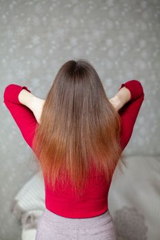 A girl with long, straight and beautiful brown hair. Hair care at home. Hair regrowth after hair coloring with henna.