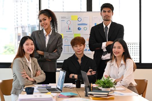 Group of successful business people attending their morning meeting in modern corporate office.