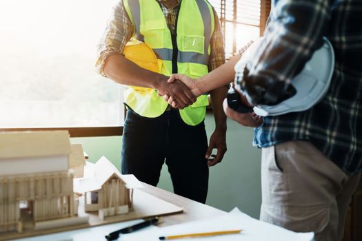 Engineers shaking hands to congratulate after success To create a building architecture successfully according to the goals that have been set.