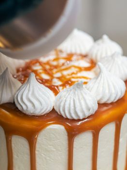 professional baker decorating a chocolate and cream cake with salty caramel