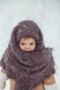 Retro photo of adorable baby in a woolen shawl in winter.