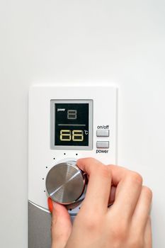 Gas boiler or boiler. A woman regulates the temperature with a temperature controller. Setting the room temperature by adjusting the gas boiler. Household concept, heating season