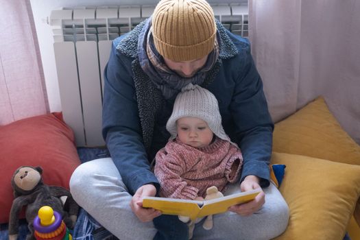 Man wearing warm clothing feeling cold checking central heating battery. Energy crisis in Europe