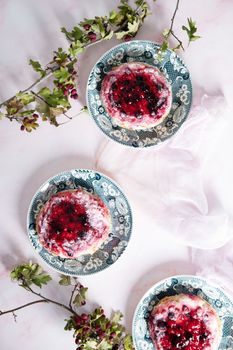 delicious cake with cream and wild berries, sprinkled with powdered sugar, top view, on a pink marble background. High quality photo