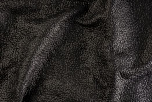 black leather texture, close-up of black genuine leather. Leather top view in folds and bumps