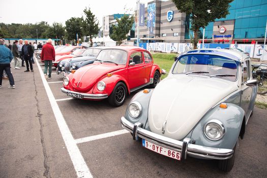 Genk, BELGIUM, August 18, 2021: classic summer meet of oldtimer at The Luminus Arena Genk, red and grey volkswagen beetle, High quality photo