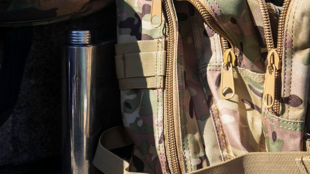 Army camouflage backpack for hiking and hunting. Brown camouflage paint for a bag, close-up photo