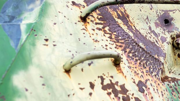 War in Ukraine, a hole in the armor of the BMP, pierced armor. Texture of green camouflage armored metal with damage and holes. Destroyed military armored personnel carrier