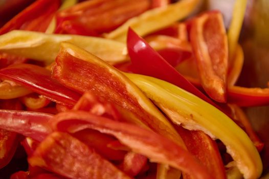 Close-ups sliced fresh raw organic sweet pepper are boiled in boiling tomato juice. Preparation of lecho salad for winter, according to traditional recipe. Preserving homegrown vegetables for winter