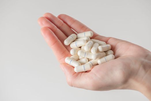 Antibiotics. The concept of antibiotic therapy, drug treatment. The use of a large number of drugs. A woman is holding a handful of antibiotics. Tablets labeled antibiotic. copy space