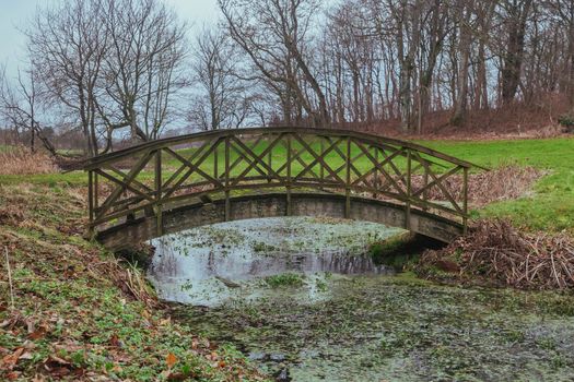 Old rotten bridge over a stream in Denmark.