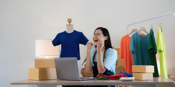 Young asian women happy after new order from customer. Surprise and shock face of asian woman success on making big sale of his online store. Online Selling.