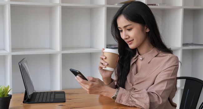 Business asian woman using smart phone at coffee shop.