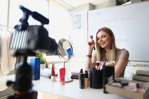 Woman makeup artist conducts makeup training on camera remotely. Blog for ability to paint women concept