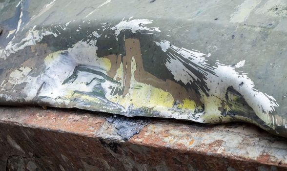 Hole or hole, armor deformation from a projectile close-up. Damaged armor of a Russian armored personnel carrier by shell fragments. War in Ukraine. Russian combat vehicle with holes in the armor