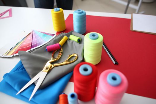 Sewing accessories and fabric on table in atelier. Accessories for sewing and needlework concept