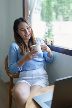 business woman sitting and drinking coffee and smiling happily.