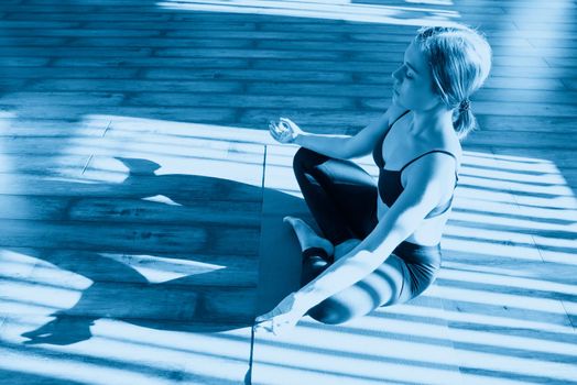 Young woman meditating sitting in lotus position