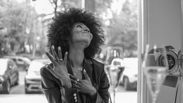 Young attractive African woman with happy cheerful smile drinking and having fun in a bar