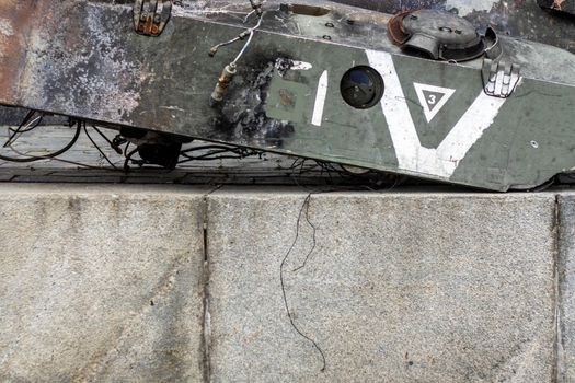 War in Ukraine. Destroyed tank with a torn off turret with a V on it. Broken and burned Russian tanks. Designation sign or symbol in white paint on the tank. Destroyed military equipment