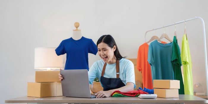 Young asian women happy after new order from customer. Surprise and shock face of asian woman success on making big sale of his online store. Online Selling.