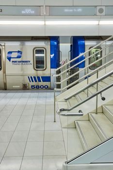Image of Clean modern subway train stairs up from side and Port Authority Trans-Hudson blue train waiting
