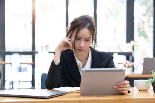 Sad Young woman employee having problems about her debts and financials. Frustrated Asian Beautiful businesswoman feeling depression, exhausted, tired, lazy during working at the office...