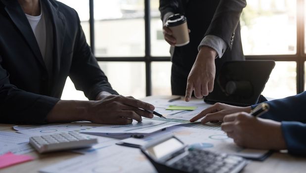Business People Meeting using laptop computer,calculator,notebook,stock market chart paper for analysis Plans to improve quality next month. Conference Discussion Corporate Concept...