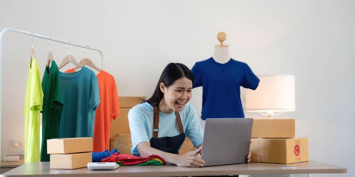 Young asian women happy after new order from customer. Surprise and shock face of asian woman success on making big sale of his online store. Online Selling.