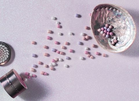 beautiful pearl balls of powder on a delicate pink surface and in a shell. High quality photo