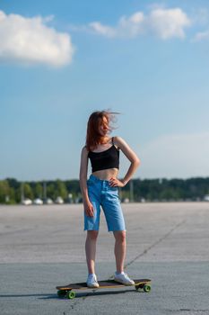 Young caucasian woman riding a longboard outdoors