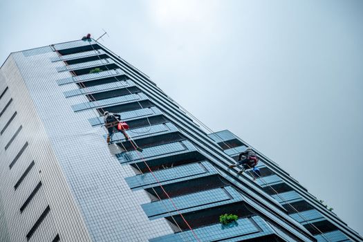 cleaning walls and glass of high-rise buildings in a big city. 