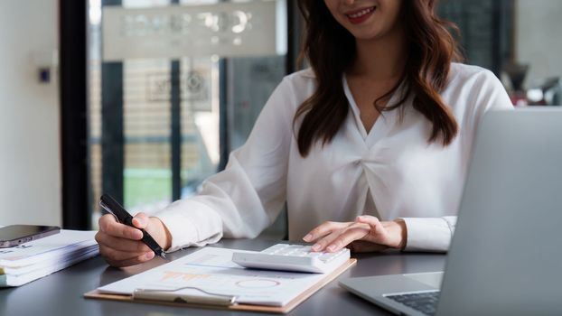 Asian Business woman working at home office and analyze financial report document. Accounting and Finance concept.