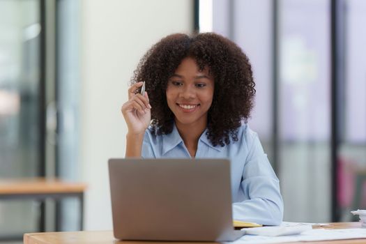 Young African American businesswoman working by laptop at office, Focus at screen laptop, reading interesting article online and finance.