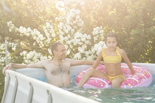 Father playing with his daughter in swimming pool.