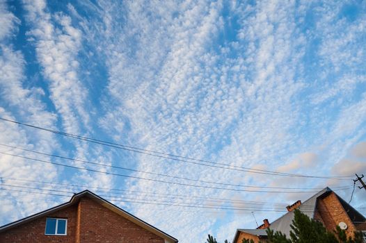 Bottom view of a blue clean sky with white fluffy clouds. Cloudscape