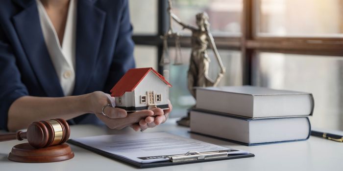 Real estate concept, businesswoman holding a house icon. House on Hand.Property insurance and security concept. Protecting gesture of female and symbol of house