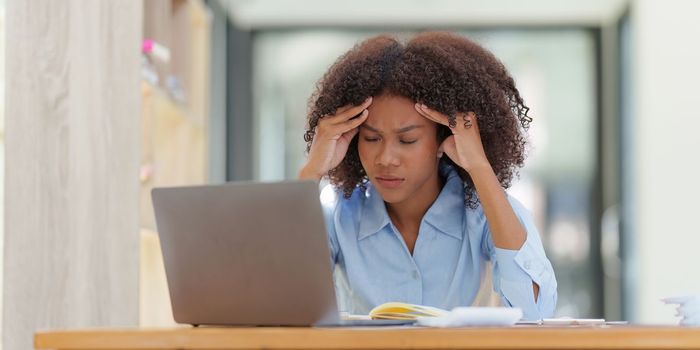 Portrait thoughtful confused young african american businesswoman looking at laptop. Stress while reading news, report or email. Online problem, finance mistake, troubleshooting.