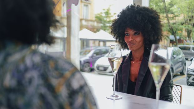 LGBT. Lesbian couple together concept. Couple of young asian woman and african woman drinking and having fun in a bar.