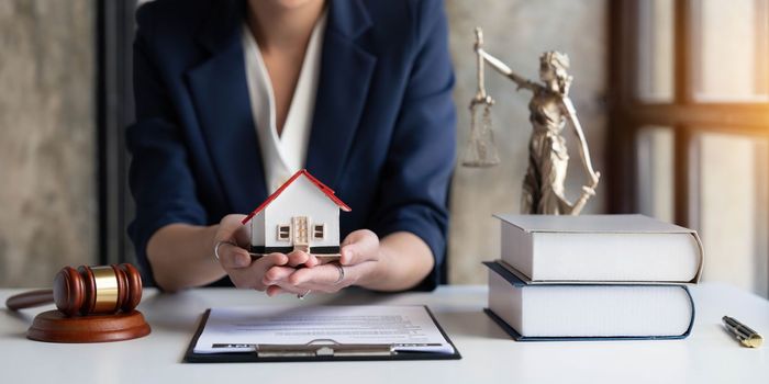 Real estate concept, businesswoman holding a house icon. House on Hand.Property insurance and security concept. Protecting gesture of female and symbol of house