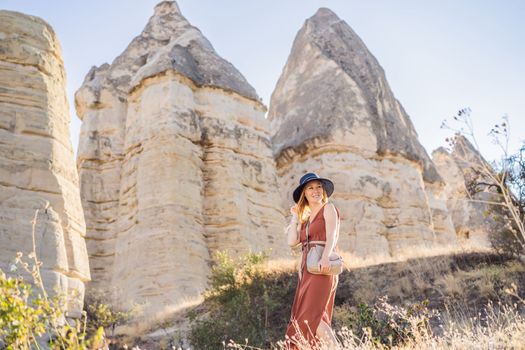 Woman tourist on background of Unique geological formations in Love Valley in Cappadocia, popular travel destination in Turkey.