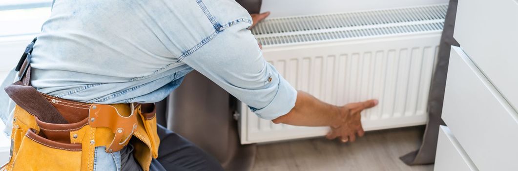 Portrait Of Male Plumber Fixing Radiator