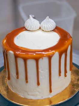 professional baker decorating a chocolate and cream cake with salty caramel