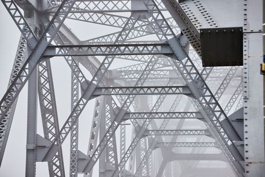 Image of Inner top of old steel bridge fading in foggy morning
