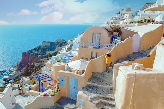 Santorini Greece, woman on luxury vacation Oia Santorini Island Greece visit the white village with beautiful building overlooking the caldera ocean