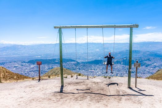 man on a swing in the mountains. 