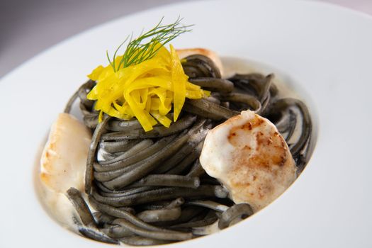 Recipe for Linguine Pasta with squid ink and scallops, yellow chioggia beet. High quality photo