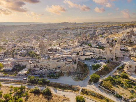 Colorful hot air balloons flying over at fairy chimneys valley in Nevsehir, Goreme, Cappadocia Turkey. Spectacular panoramic drone view of the underground city and ballooning tourism. High quality.