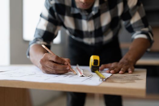 Architect man working with blueprints for architectural plan, engineer sketching a construction project, green energy concept.